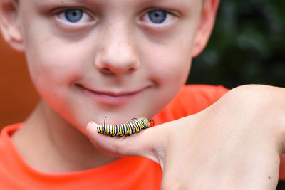 Close-up of boy with caterpillar