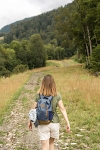 Rear view of a man walking on road