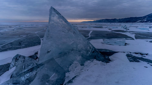 Snow covered landscape against sky during sunset. baykal.