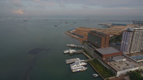 High angle view of buildings by sea against sky