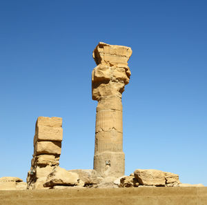 Low angle view of old ruins against blue sky