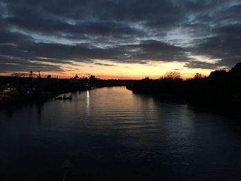 Scenic view of river against sky at sunset