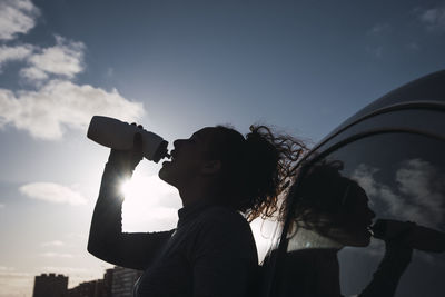 Woman silhouette drinking water alone