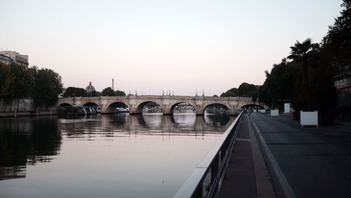 Bridge over river against sky during sunset