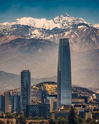 Skyscrapers against snowcapped mountain