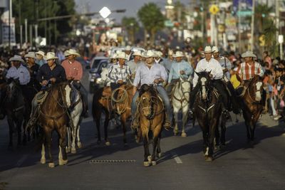 Group of people walking on road in city