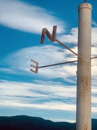 Information sign on pole against sky