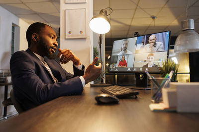 Young man using mobile phone while sitting on table