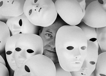 Portrait of a man surrounded by white masks