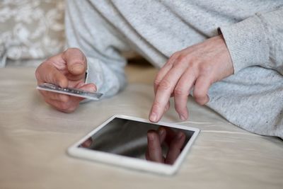 Midsection of man using mobile phone