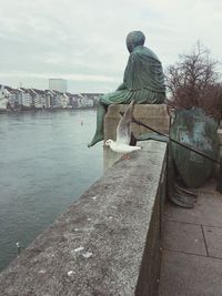 Man by river against sky