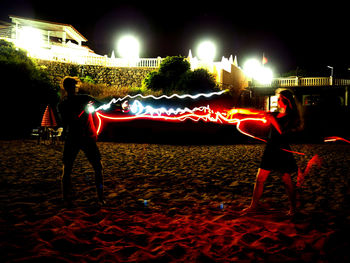 Man playing with illuminated lights at park