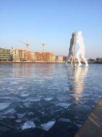 Statue in city against clear sky