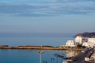 Sailboats in sea against sky in city