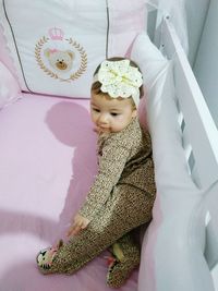 High angle view of baby girl in crib at home