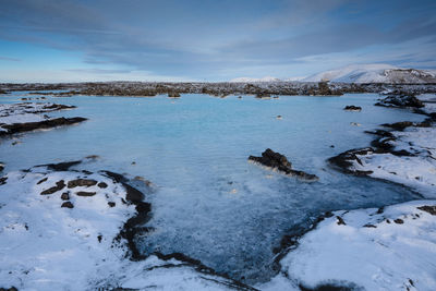 Scenic view of lake against sky during winter