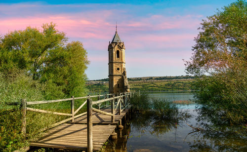 Bridge over lake amidst buildings against sky