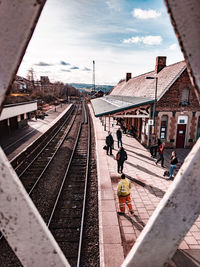 People on railroad station platform against sky