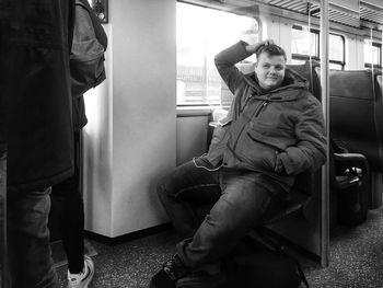 Full length of man sitting in train