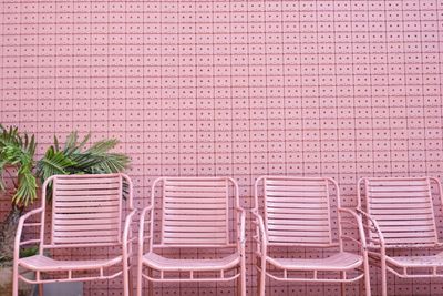 Empty pink chairs arranging against wall