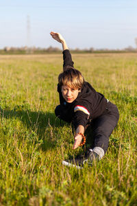 Caucasian young woman practicing wushu martial art in a green meadow