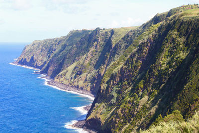 Scenic view of sea and mountains against sky