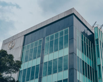 Low angle view of glass building against sky