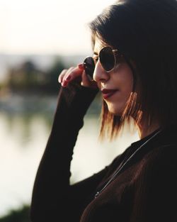 Portrait of beautiful woman holding sunglasses