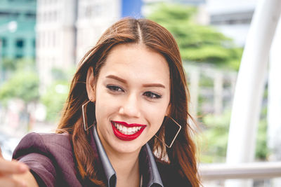 Close-up of happy young woman in city