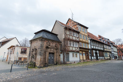 Old building by road against sky