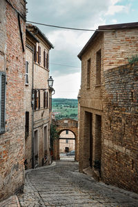 Narrow alley amidst old buildings against sky