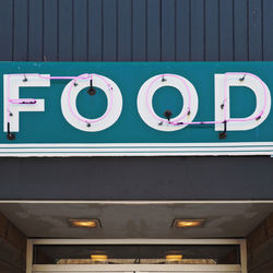 Low angle view of illuminated sign on wall