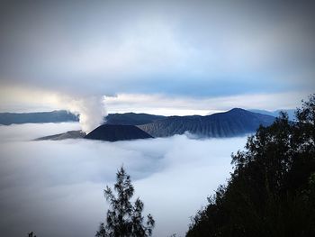 Smoke emitting from volcanic mountain against sky