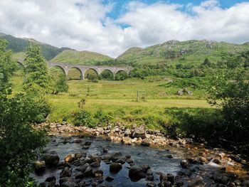 Arch bridge over river against sky