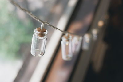 Close-up of bottles hanging on string
