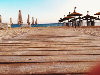 Pier on beach against sky