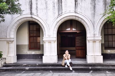 Full length of woman standing in front of historic building