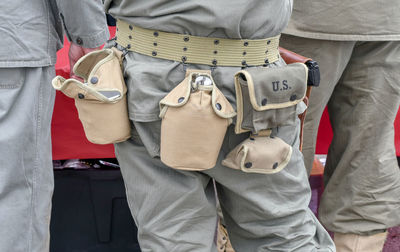 A soldier sports a belt with important tools hanging from it for military use in the desert