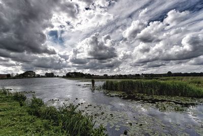 Scenic view of lake against cloudy sky