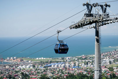 Overhead cable cars in city against clear sky