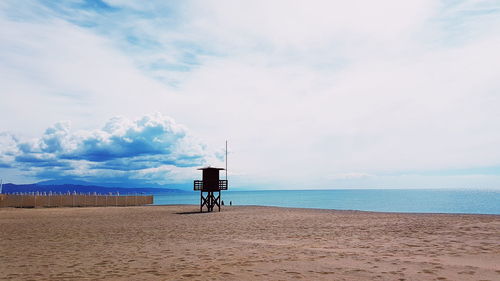 Lifeguard hut on beach against sky