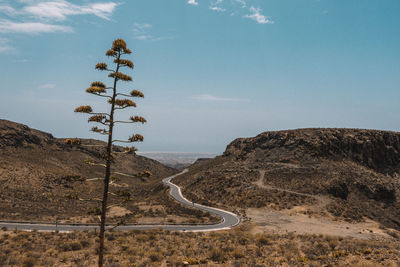 Road by mountain against sky