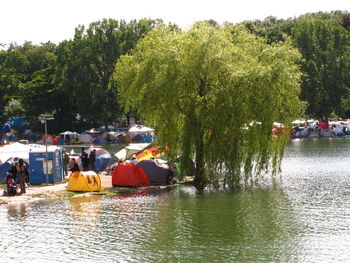 People in boat on river against trees