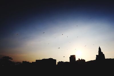 Low angle view of silhouette buildings against sky during sunset