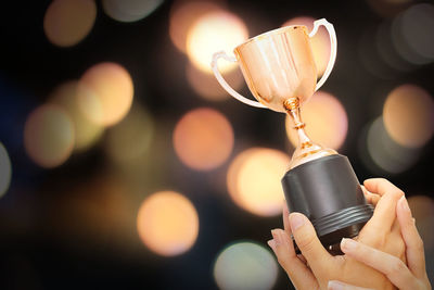 Trophy on winner hand with bokeh background