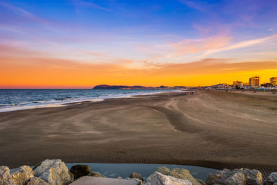 Scenic view of beach against sky during sunset