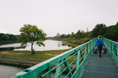 Rear view of man on river against sky