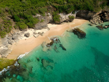 High angle view of rocks in sea and beach