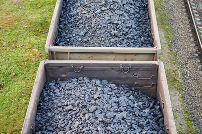 Railway cargo cars loaded with coal. freight train transporting coal, wood, fuel. top view.