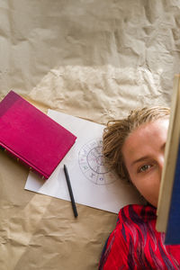 Woman reading a book laying down on the astrological chart